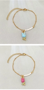 Détail de pendentifs tulipes en émail avec perles blanches sur chaînes dorées