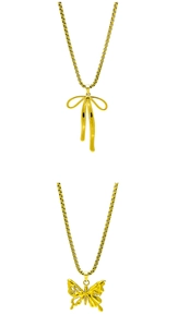 Detail of golden box chain necklaces with butterfly and bow charms on white background