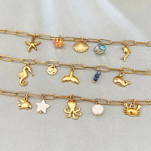 Golden stainless steel ocean charm bracelet featuring starfish and sea horse pendants