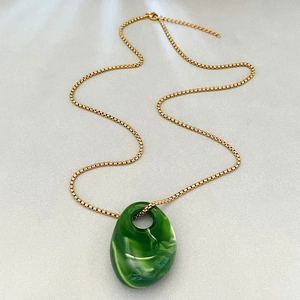 Modern gold box chain necklace featuring a green marbled irregular acrylic pendant