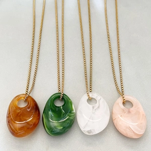 Irregular geometric acrylic drop necklaces in amber, green, white, and pink with gold chains