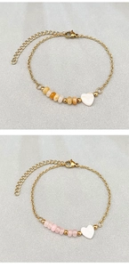 Detailed shot of golden chain bracelets with heart shell charms and colorful stone beads
