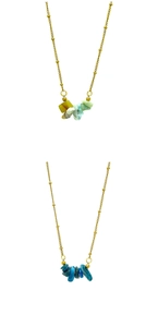 Dettaglio di catene con perline placcate oro 18k e pendenti in pietre naturali blu e verdi