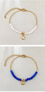 Dettaglio di bracciali con perline in acciaio inossidabile, stella e chiusura a moschettone