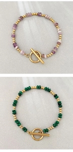 Dettaglio di bracciali bohémien in pietra naturale con perline dorate e chiusura a levetta OT
