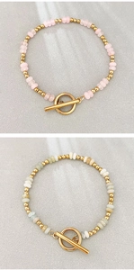 Dettaglio di bracciali bohémien con pietre naturali e chiusura a levetta OT dorata