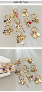 Detailed close-up of golden marine charm earrings featuring seahorse and starfish designs