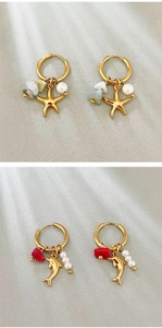Detailed macro view of gold-plated sea star and dolphin earrings with pearls and gemstones