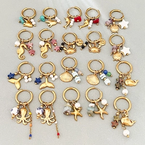 Collection of golden ocean-themed dangle hoop earrings with marine charms and pearls