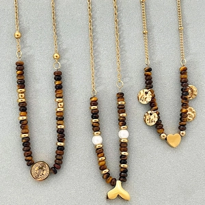 Colliers en oeil de tigre avec pendentifs dorés tels que pièces et coeurs