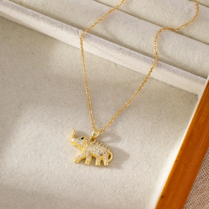 Collier éléphant en acier titane doré avec micro-pavage de zircons sur plateau en velours
