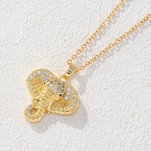 Gros plan d'un pendentif éléphant doré serti de zircons sur une surface texturée