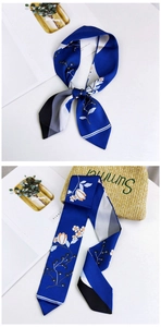 Close-up of a navy blue floral twilly scarf styled on a bag for a fresh summer look