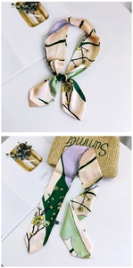 Detail of floral silk ribbon scarf tied on a straw bag with vintage plum blossom pattern