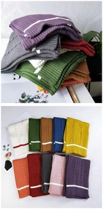 Close-up of assorted ribbed knit scarves with white stripes in various vibrant colors