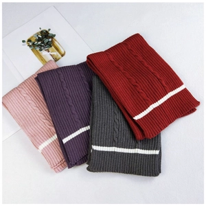 Detail of cable knit scarves in pink, purple, gray and red with contrast stripe hem