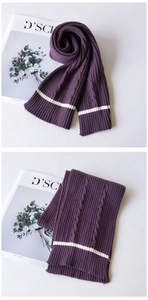 Detail of purple chunky cable knit scarf featuring white stripe accents and thick texture