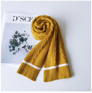 Detail of chunky cable-knit ginger scarf with white stripe accent on soft wool material
