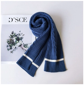 Detailed close-up of navy blue cable knit scarf with classic white stripe accents