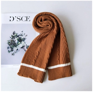 Detail of caramel cable knit scarf with white stripes and thick soft winter texture