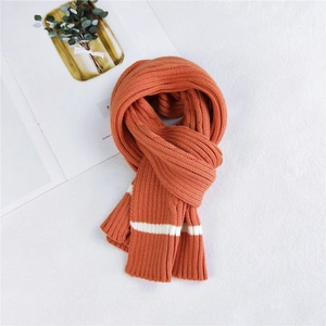 Thick orange knitted scarf with white stripes and warm ribbed texture for winter