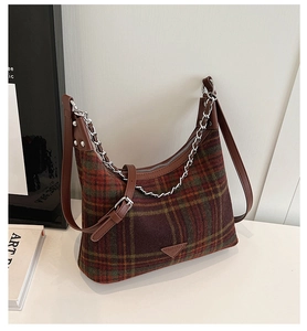 Detail of plaid wool shoulder bag with brown leather strap and silver metal chain