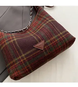 Detail of classic plaid wool shoulder bag with metal chain strap and logo patch