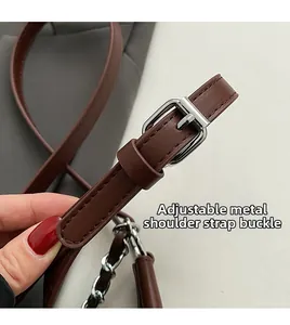 Detail of adjustable leather shoulder strap with silver metal hardware buckle on bag