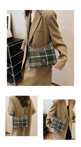 Close-up of retro green plaid tweed handbag with metal triangle logo and chain strap
