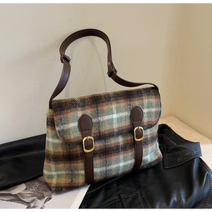 Detailopname van de vintage geruite schoudertas van wol met bruine leren riempjes