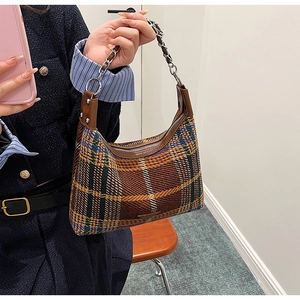 Close-up of vintage plaid hobo bag featuring tweed fabric and silver chain strap details