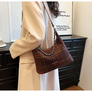 Detail of vintage plaid wool shoulder bag with decorative silver chain and leather strap