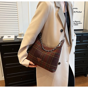 Close-up of retro plaid fabric shoulder bag with metal chain and leather straps