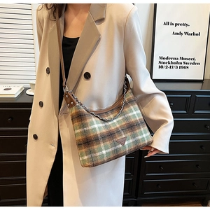 Detail of vintage plaid wool shoulder bag with brown leather trim and metal chain strap