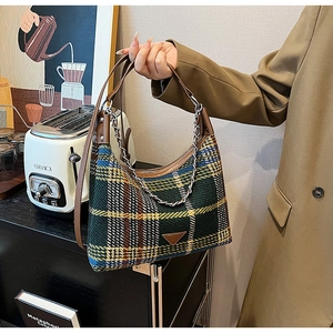Detailed close-up of plaid tweed shoulder bag featuring leather trim and silver chain