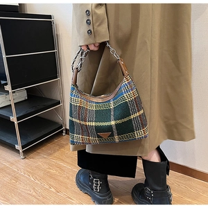 Detail of classic plaid wool shoulder bag with vintage metal chain and leather handle