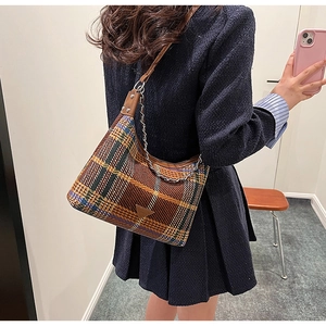 Detail of plaid hobo bag featuring retro woolen texture and elegant metal chain strap