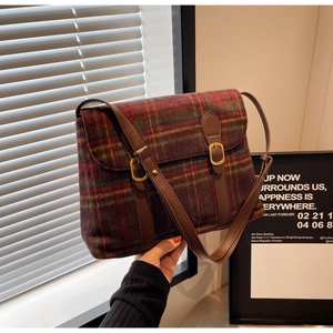Detail van vintage geruite schoudertas van kleurrijk tweed met bruine leren riem