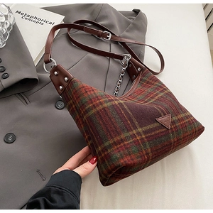 Close-up of vintage wool plaid bag with brown leather strap and silver chain detail