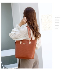 Détail d'un sac cabas marron tressé avec des ferrures dorées et le logo de la marque