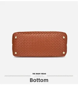 Gros plan du fond du sac en cuir tressé avec pieds de protection en métal doré brillant
