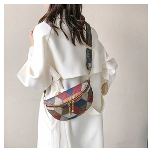 Détail du sac bandoulière géométrique coloré avec large sangle jacquard porté par un mannequin