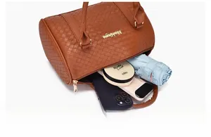 Vue intérieure du sac cylindre tressé marron montrant sa grande capacité de rangement