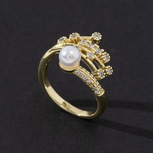 Detail of elegant gold-plated ring with large white pearl and pavé cubic zirconia