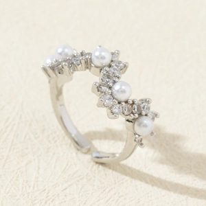 Detailed close-up of adjustable silver wave ring with five white pearls and zircons