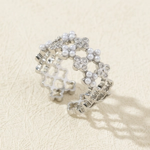 Detail of silver adjustable open ring with hollow flower design and zircon pearls