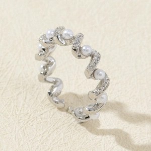 Macro detail of silver wave ring with white pearls and sparkling cubic zirconia