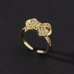 Gros plan d'une bague nœud dorée avec pavage scintillant de zircones cubiques blancs