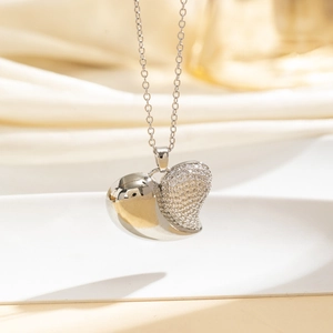 Dettaglio macro della collana a cuore in argento con lato lucido e pavé di zirconi