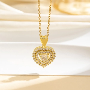 Dettaglio del ciondolo a cuore dorato con pietre di zircone e gancio a forma di cuore